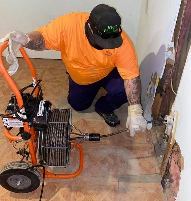 RWC Plumbing & Restoration technician working on a drain